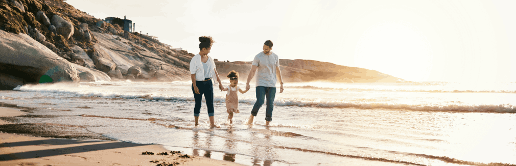 Família a passear à beira-mar, aproveitando a paz de espírito trazida pelo seguro de vida doenças graves.