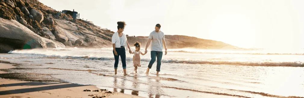 Família a passear à beira-mar, aproveitando a paz de espírito trazida pelo seguro de vida doenças graves.