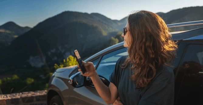  Jovem feliz encostada a um carro, a escolher seguro automóvel novo