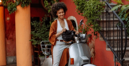 Mulher jovem feliz depois de decidir entre comprar uma moto ou scooter.