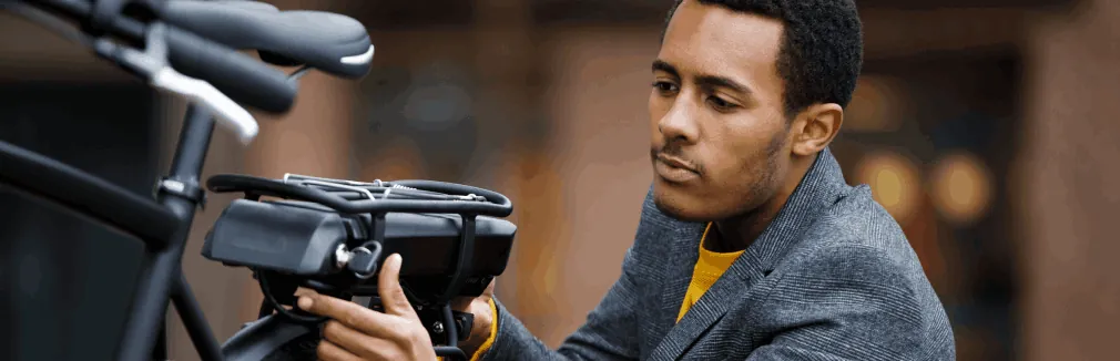 Jovem verifica a sua bicicleta elétrica antes de iniciar viagem