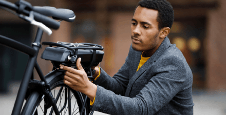 Jovem verifica a sua bicicleta elétrica antes de iniciar viagem