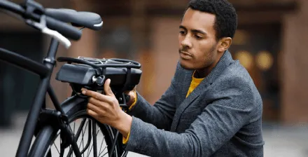 Jovem verifica a sua bicicleta elétrica antes de iniciar viagem