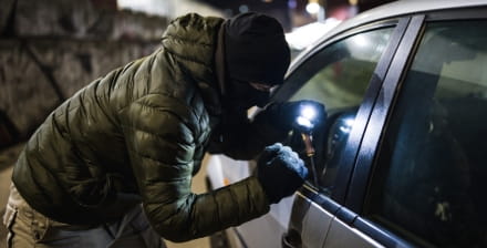 Ladrão tenta arrombar o carro com um ferro de abrir fechaduras.