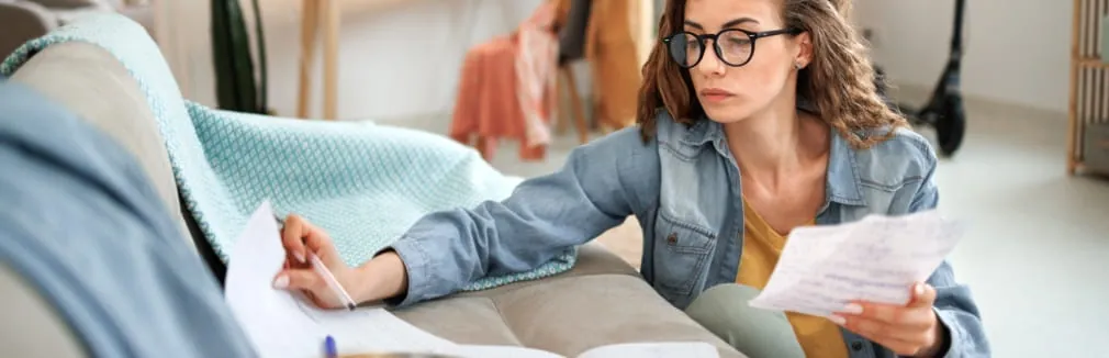 Jovem mulher sentada no chão da sala ocupada a organizar os documentos.