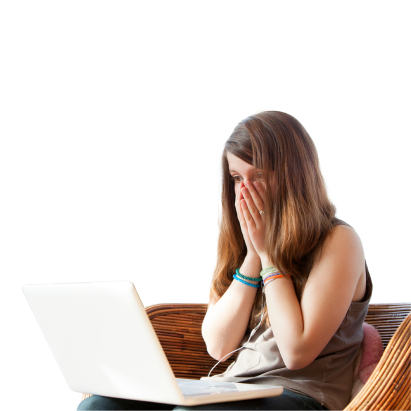 Mulher jovem sentada, com portátil sobre joelhos, a olhar para ecrã com mãos no rosto