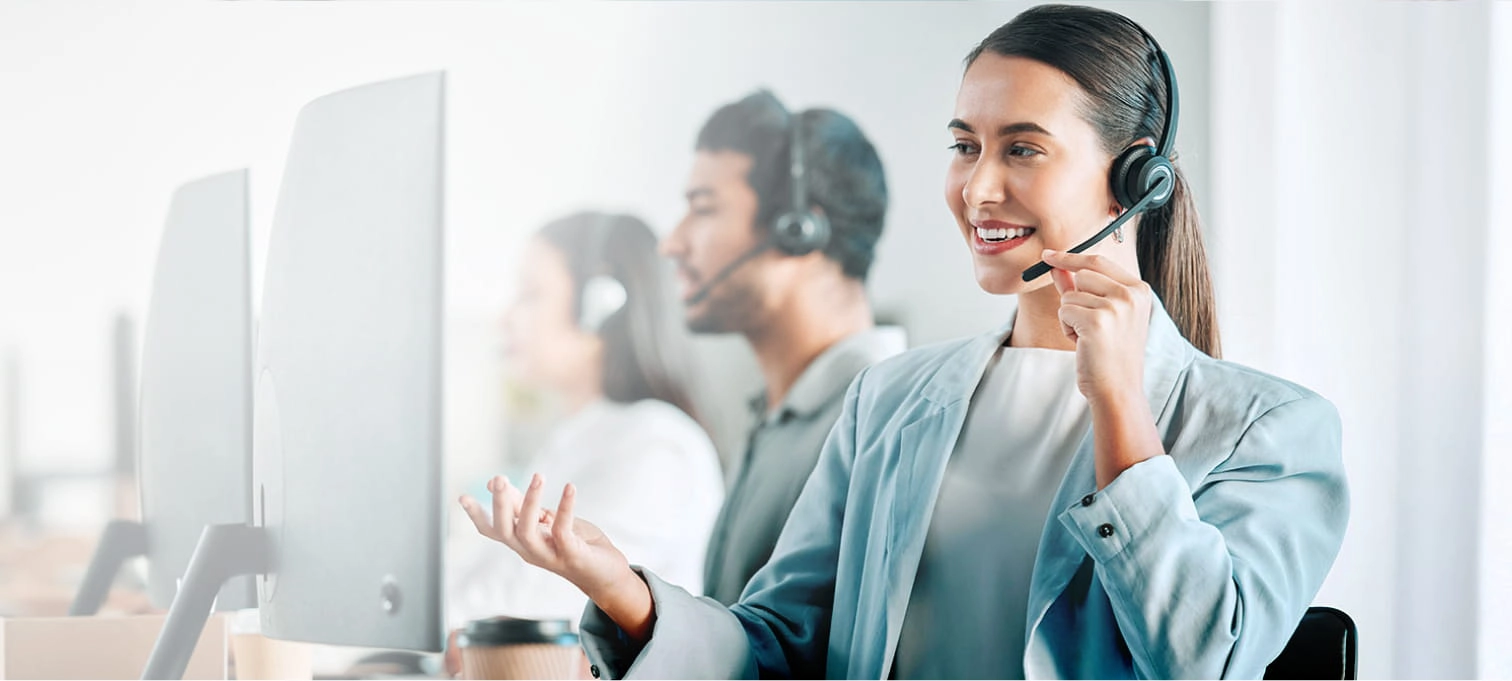 Mulher com fones nos ouvidos a trabalhar num contact center, concentrada em atender chamadas de clientes.