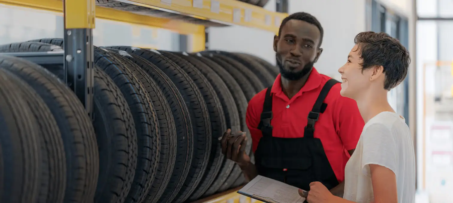 Funcionário e cliente numa loja de pneus